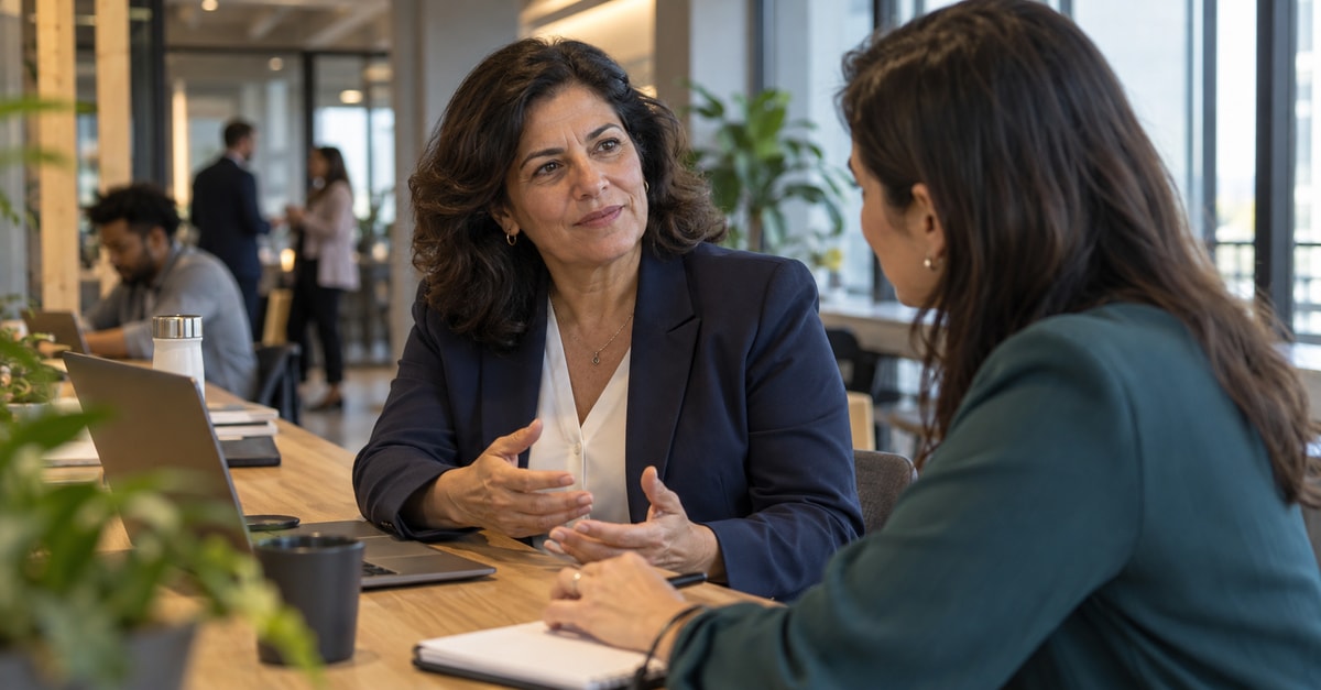 Líder de recursos humanos conversa com uma profissional em uma reunião de trabalho.